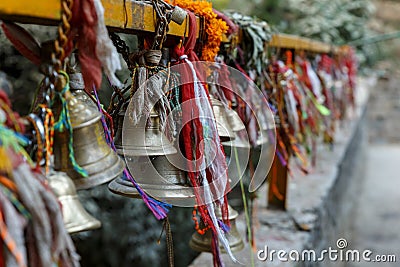 Metal bells hang on chains in a Hindu temple Stock Photo