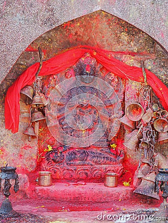 Metal bells offered by devotees at Kali Temple. Shrine full of red pigment to worship Goddess Kali at Dhulikhel in Nepal Stock Photo