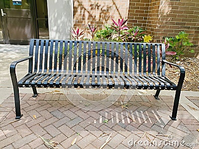 Metal bench by brick wall Stock Photo