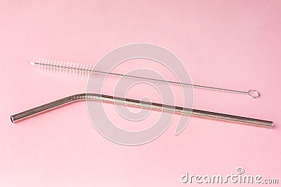 Metal, bendy drinking straw and steel cleaning brush on pink background. Aluminum stainless reusable bar equipment for drink Stock Photo