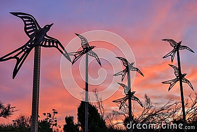 Metal birds flying into the sunset skies. Shoreline Park, Mountain View, California Stock Photo