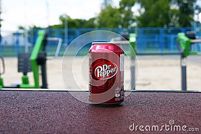 A metal bottle of Dr Pepper drink on the background of a street sports ground. Editorial Stock Photo