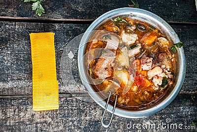 Metal bowl with goulash bogracs on a wooden table Stock Photo