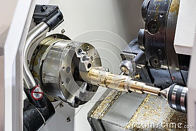 Metal brass workpiece set on spindle chuck of automatic high precision Cnc lathe turning 4 axis machine with function side drill Stock Photo