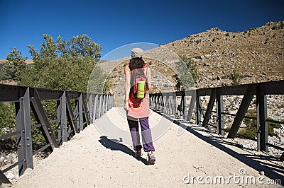 Metal bridge and trekking woman Stock Photo