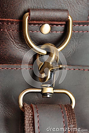 Metal carabiner on a leather belt, on the background of a leather bag. Close up Stock Photo
