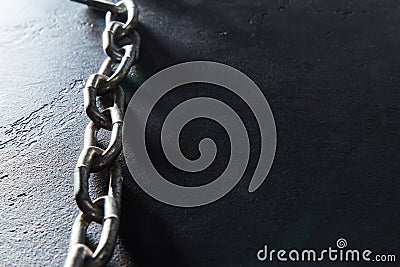 Metal chain on black textured background. Connected steel links for fastening or securing objects, empty place for text Stock Photo