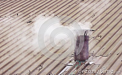 Metal chimney on copper roof with smoke - image with copy space Stock Photo