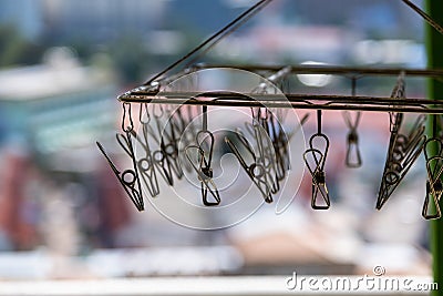 metal clothespins hanging with wire on blur background Stock Photo