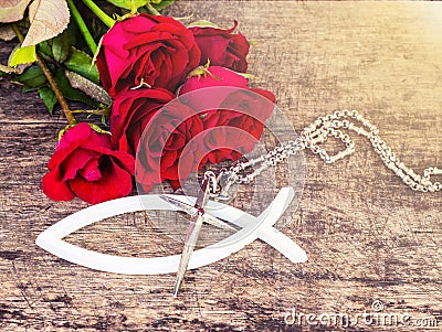 The metal cross with red roses on wooden table Stock Photo