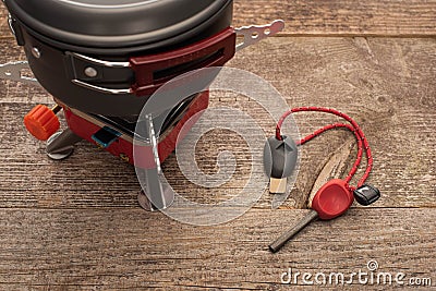 Metal dish on gas-burner near spark lighter on wooden surface Stock Photo