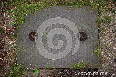 Metal drain cover in concrete path Stock Photo