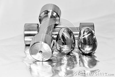 Metal dumbbells and steel eggs, the concept of sports training and the achievement of muscle strength Stock Photo