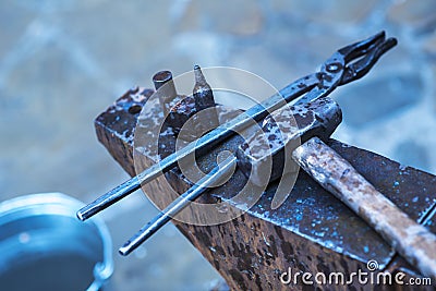 A metal fabricator utilizing a torch to heat up a piece of metal in order to shape it utilizing a forging technique Stock Photo