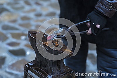 A metal fabricator utilizing a torch to heat up a piece of metal in order to shape it utilizing a forging technique Stock Photo