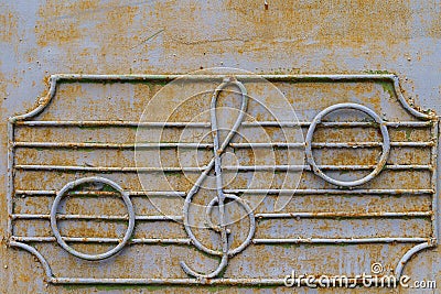 Metal fence of the old music school with decorative symbols in the form of a treble clef and notes on the stave Stock Photo