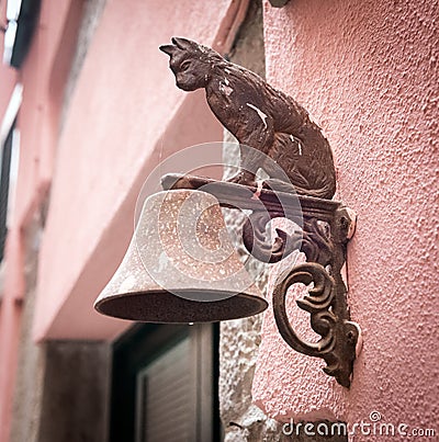Metal figure of cat as decoration of bell carried on a wall Stock Photo