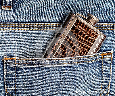 Metal flask for alcohol in the pocket of jeans. Stock Photo