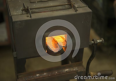 Metal forge heating steel in blacksmith shop Stock Photo