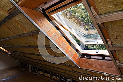 Metal frames on attic skylight window and environmentally friendly and energy efficient thermal insulation rock wool Stock Photo