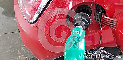 Rubber fuel nozzle inside the gas tank of mini sport car filling gasoline in self service station Stock Photo