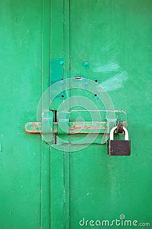 Metal gate lock on green gates. Stock Photo