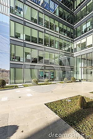 Metal and glass facade with hedged gardens at the entrance of an office building Stock Photo