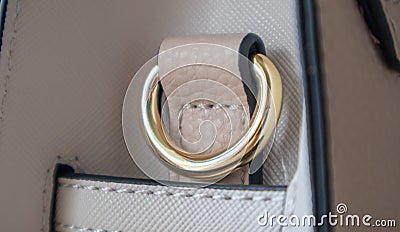 Metal gold loop oval ring attached to a leather bag. Selective focus. Part for a secure connection between two objects. Sewing Stock Photo
