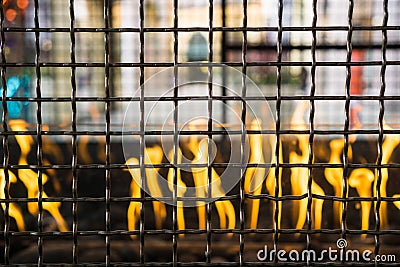 Metal grid enclosing an outdoors fire used for getting warm Stock Photo