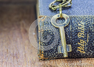 The metal key on holy bible on wooden table Stock Photo