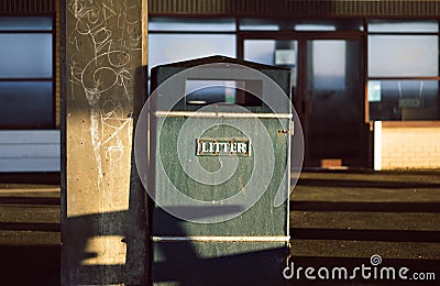 Metal litter box in the coast town. Sunlight, shadows. Defocused blurred background. Stock Photo