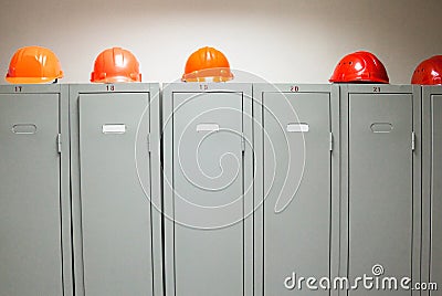 Metal lockers and plastic hard hats Stock Photo