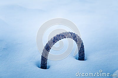 A metal loop sticking out of the snow. Part of a breakwater at the coast of Baltic sea in winter. Stock Photo
