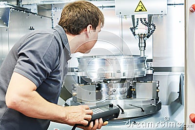 Metal machining industry. Worker operating cnc milling machine Stock Photo