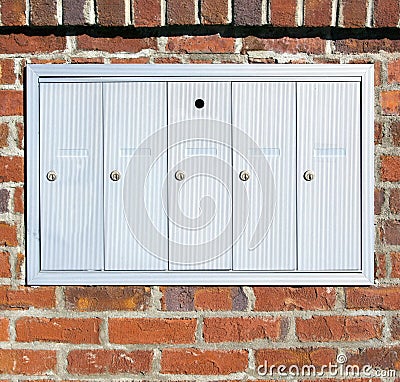 Metal mailboxes mounted on brick wall Stock Photo