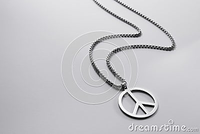 Metal medallion, with a pendant in the form of a symbol of peace on a white background Stock Photo