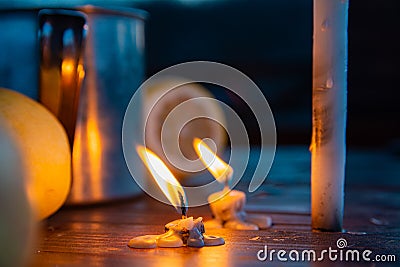 A metal mug of tea, lemon, apples and lighted candles on the wooden table a cold autumn day Stock Photo
