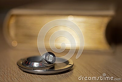 Metal nickel-plated details of a vintage camera lying on a blurred background of old book with a gold edge Stock Photo