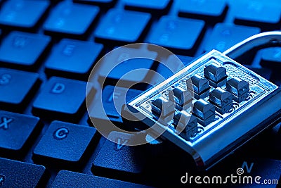 Metal number combination pad lock on a computer keyboard. Internet and network security theme. Blue tone background Stock Photo