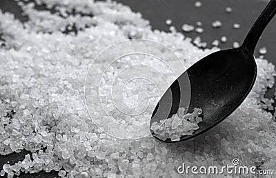 Metal old spoon with coarse sea salt on a dark background Stock Photo