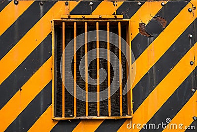 Metal orange window on a black and orange painted metal wall Stock Photo