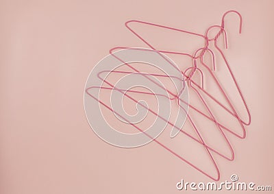 Metal pink hangers for clothes on pink background. Empty cloth hanger template. Fashion blog, sales, store, online shopping Stock Photo