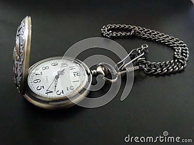 Pocket watch with chain in dark background Stock Photo