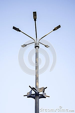 Metal pole with five modern LED lights set against clear blue sky. Street lighting. Bottom view. Copy space Stock Photo