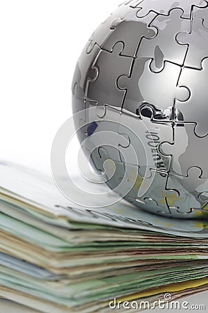 Metal puzzle globe with money Stock Photo