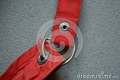 metal rivet and carabiner in a red one cloth harnes Stock Photo