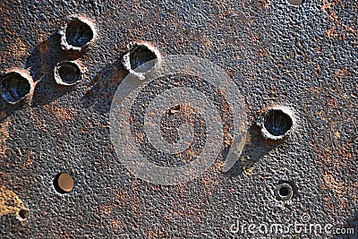 A metal rusty plate of the armor of an old mortar with traces and bullet holes. Stock Photo