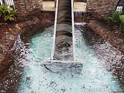 Metal screw spiral water elevator with pond Stock Photo