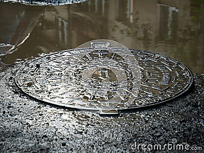 Metal sewage cover in the flooded city Stock Photo