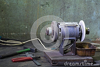 Metal Sharpening Machine With Variety of Circles Placed together With Fitters Workign Tools in Workshop Stock Photo